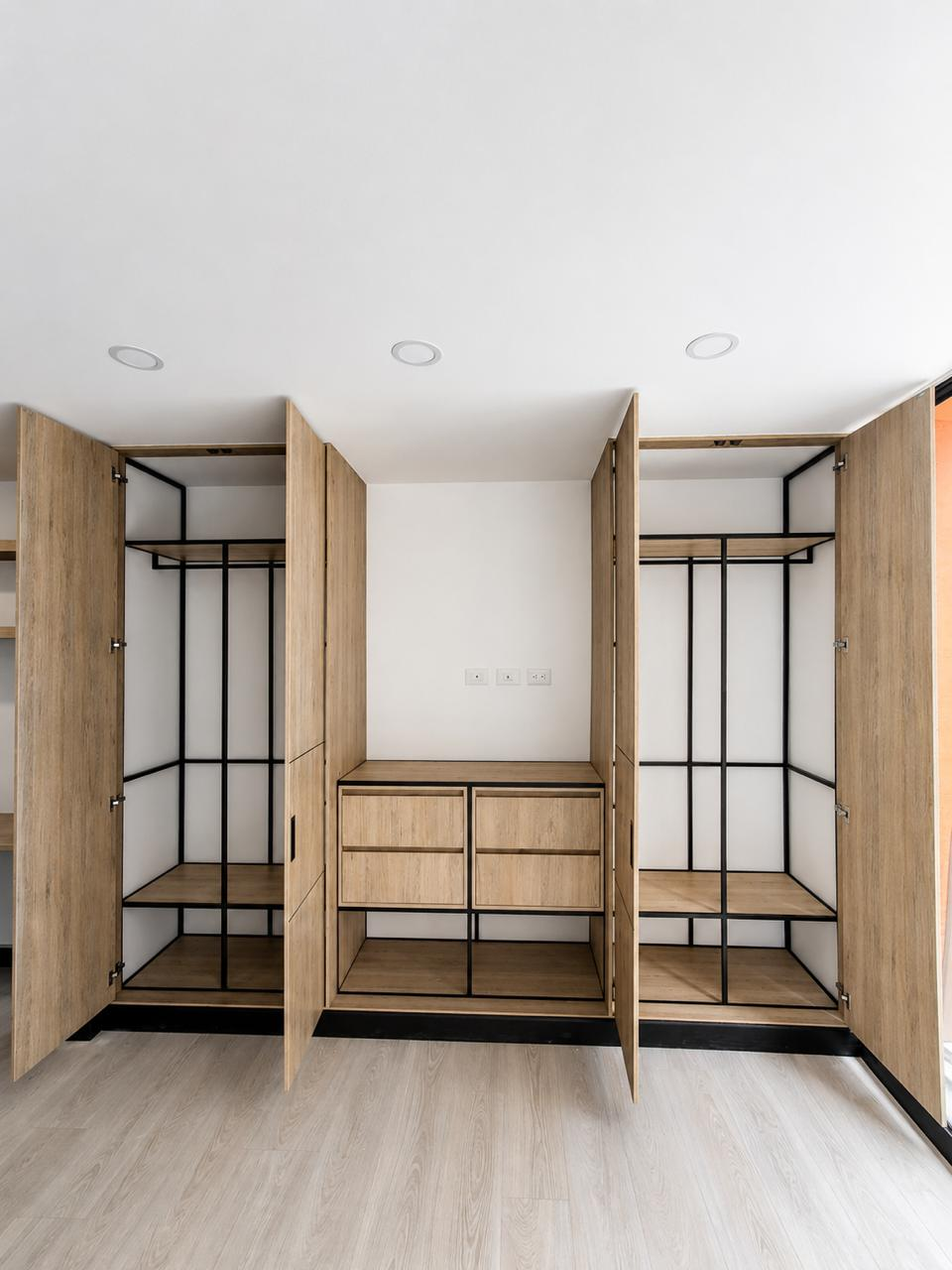 Closets abiertos en madera con estructura interior metálica negra y cajonería